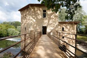 un vieux bâtiment sur un pont sur une rivière dans l'établissement Le Moulin de Pézenas - Pierres d'Histoire, à Pézenas