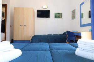a living room with a blue bed and a tv at B&B Spiaggia di Ponente in Scicli