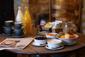 einen Holztisch mit Obstschalen und einer Zeitung in der Unterkunft Horse and Groom in Moreton-in-Marsh