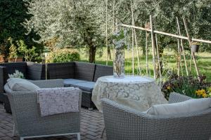 patio z krzesłami i stołem z wazonem w obiekcie Girelli Sorelle w mieście Bussolengo