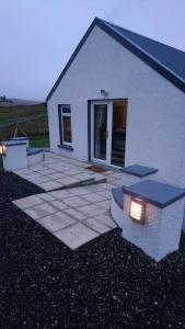 a house with a patio with a building at The Chalet, 444 North Lochboisdale in Lochboisdale