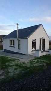 洛赫博伊斯代爾的住宿－The Chalet, 444 North Lochboisdale，黑色屋顶的白色房子