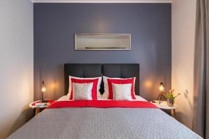 1 dormitorio con 1 cama grande con almohadas rojas y blancas en Apartment Bordeaux 29, en Rovinj