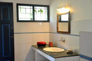 a bathroom with a sink and a mirror at Villa Jacaranda in Varkala