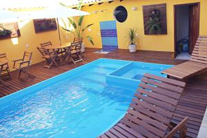een zwembad op een terras met een tafel en stoelen bij Pousada Maravilha de Paraty in Paraty