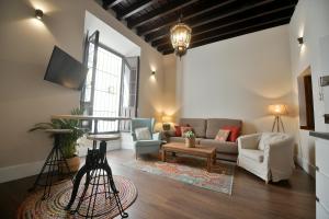 a living room with a couch and a tv at Apartamento Arenal in Seville