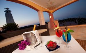 a table with two glasses and a bowl of fruit on it at Grand Hotel In Porto Cervo in Porto Cervo