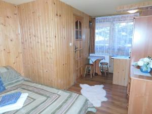 a bedroom with a bed and a kitchen with a table at Pokoje Goscinne Monika II in Zakopane