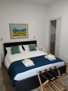 a bedroom with a large bed with two towels on it at ARNO ROOMS VERONA in Verona