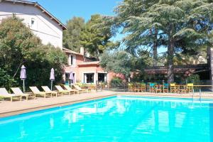 uma piscina com espreguiçadeiras e um resort em Les Jardins de Cassis em Cassis