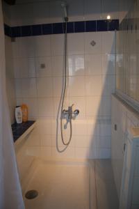 a shower with a hose in a bathroom at Maison cathedrale proche Paris in Pavant