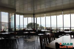 ein Restaurant mit Tischen, Stühlen und Fenstern in der Unterkunft Mas Butik Otel in Edremit
