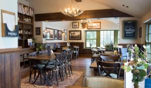 a restaurant with tables and chairs and a bar at George III Hotel in Penmaenpool