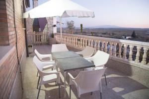 una mesa y sillas en un balcón con sombrilla en Aranaz Bardenas, en Cadreita