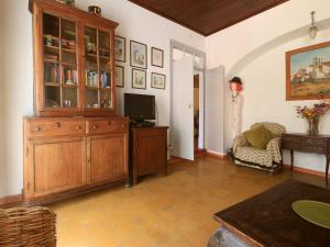 a living room with a tv and a wooden cabinet at Tavira Townhome with private Garden in Tavira