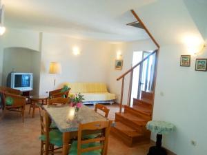 een woonkamer met een tafel en stoelen en een bank bij villa NIKOLA in Brela