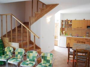 ein Wohnzimmer mit einer Treppe, einem Tisch und Stühlen in der Unterkunft villa NIKOLA in Brela
