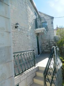 een stenen gebouw met een trap en een balkon bij villa NIKOLA in Brela