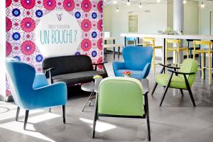 a waiting room with chairs and a table with a sign at ibis Styles Perpignan Canet En Roussillon in Canet-en-Roussillon