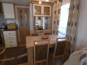 - une cuisine avec une table, des chaises et un comptoir dans l'établissement Crossbill Chalet - 71, à Boat of Garten