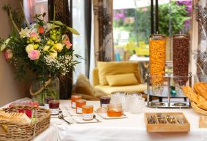 stół z jedzeniem i wazonem kwiatów w obiekcie Les Jardins de Cassis w Cassis