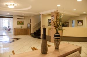 un vestíbulo con un jarrón de flores sobre una mesa en Dona Adelia Hotel e Restaurante en Flores da Cunha