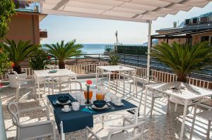 un patio con mesas y sillas y el océano en B&B Amalfè, en Maiori