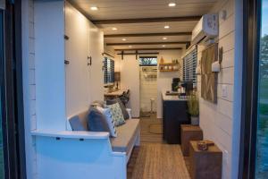 a tiny house with a kitchen and a hallway at Stillwater House Elegant tiny container home Near Magnolia in Waco