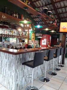 a bar with a row of bar stools at Pousada do Irlandês in Pirenópolis