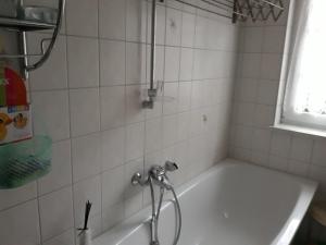 a bathroom with a tub with a shower at 5 Gartenstraße in Angermünde