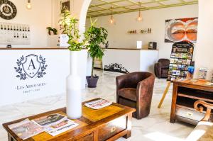 a coffee shop with a table and chairs at Hôtel les Arbousiers in Calvi