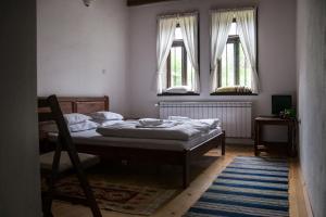 a bedroom with a bed and two windows at Mutafova Guest House in Veliki Preslav +49 photos