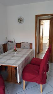 a dining room with a table and two red chairs at 5 Gartenstraße in Angermünde