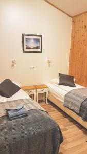 a bedroom with two beds and a picture on the wall at Guesthouse Skálafell in Skálafell