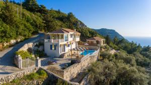 dom na zboczu wzgórza z basenem w obiekcie Blue Chill Villa w mieście Tsoukalades