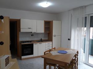 a kitchen with white cabinets and a table with a dining room at Sweet Home Arco in Arco
