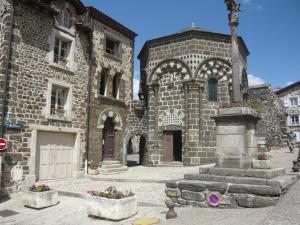 an old stone building with flowers in front of it at Le Petit Séguret in Le Puy en Velay