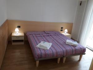 a bedroom with a bed with two tables and two towels at Sweet Home Arco in Arco