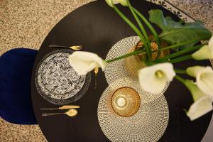 un tavolo con due piatti e un vaso con fiori di Ellie Luxury Apartment a Roma Altre 29 foto