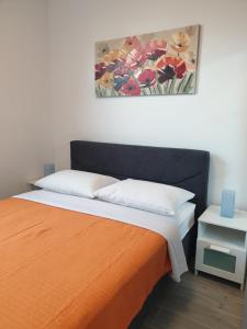 a bedroom with an orange bed with a painting on the wall at Apartment Mary in Trogir +158 photos