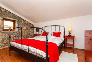 ピネジチにあるVilla Korinaの赤い掛け布団が敷かれたベッドのある寝室