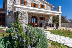 a stone house with a balcony and flowers at Villa Korina in Pinezici