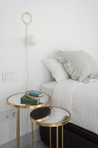 een slaapkamer met 2 tafels naast een bed bij La casa del Lagar 10 in Sevilla