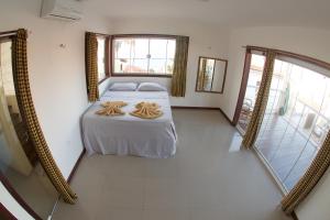 um quarto com uma cama e uma grande janela em Casa Flecha em Canoa Quebrada