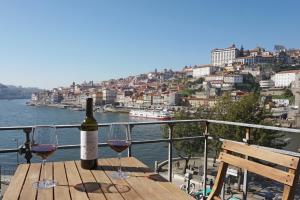 a bottle of wine sitting on a table with two glasses at Porto View by Patio 25 in Vila Nova de Gaia