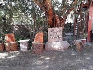 un gruppo di tronchi, una tavola e un albero di Hostal Las Kañas a San Pedro de Atacama