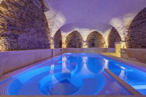 an indoor swimming pool in a building with stone walls at Monastero Di Cortona Hotel & Spa in Cortona