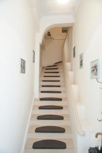 a staircase in a house with white walls and carpeted floors at Lefkada Family Apartment in Lefkada