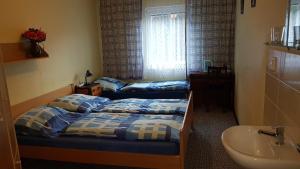 - 2 lits jumeaux dans une chambre avec lavabo et salle de bains dans l'établissement Hostel Fortuna, à Špindlerův Mlýn