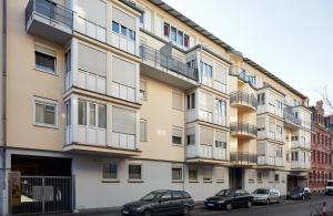 un edificio de apartamentos con coches estacionados frente a él en Apartments 4 YOU - Lange Straße, en Fürth